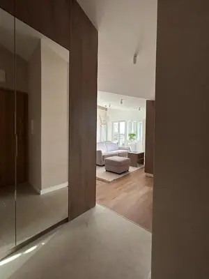 a living room with a couch and a large mirror at Cracow Center Jacuzzi & Sauna Penthouse Retreat in Kraków