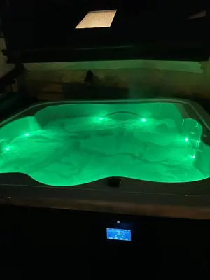 a green hot tub in a dark room at Cracow Center Jacuzzi & Sauna Penthouse Retreat in Kraków