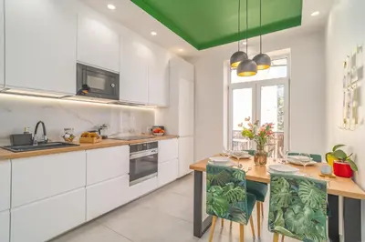 a kitchen with white cabinets and a green ceiling at Kraków Suite - Balcony, Workspace - by Rentujemy in Kraków