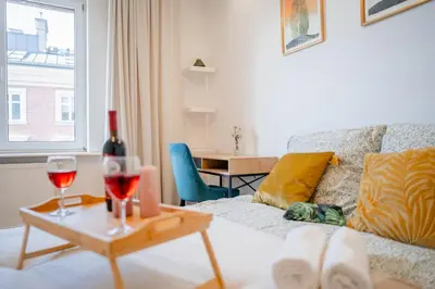 a living room with a couch and a table with wine glasses at Kraków Suite - Balcony, Workspace - by Rentujemy in Kraków