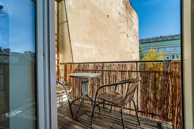 a patio with a table and chairs on a balcony at Kraków Suite - Balcony, Workspace - by Rentujemy in Kraków