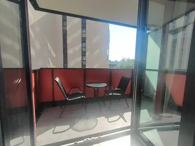 a kitchen with white cabinets and a black appliance at Apartament z 2 pokojami i balkonem Tauron Arena in Kraków