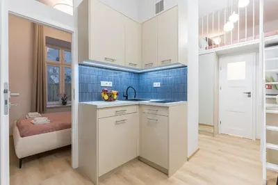 a kitchen with white cabinets and a sink at CracWoW S31 Apartment in Kraków