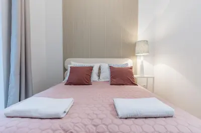 a large pink bed with two pillows on it at CracWoW S31 Apartment in Kraków
