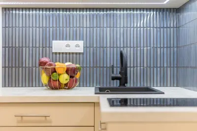 a bowl of fruit on a counter next to a sink at CracWoW S31 Apartment in Kraków