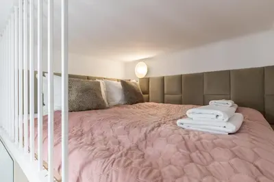 a bedroom with a pink bed with towels on it at CracWoW S31 Apartment in Kraków