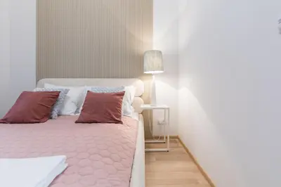 a bedroom with a bed with pillows and a lamp at CracWoW S31 Apartment in Kraków