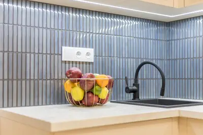 a bowl of fruit on a counter next to a sink at CracWoW S31 Apartment in Kraków