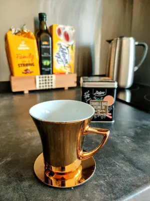 a gold coffee cup sitting on a counter top at Cozy Studio for a Couple - 10 min from the airport in Kraków