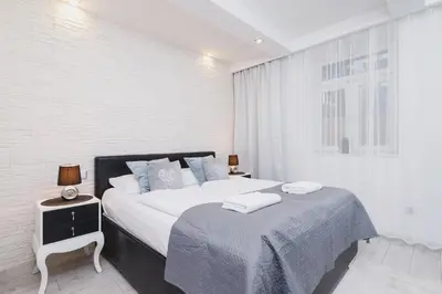 a white bedroom with a large bed and a window at Comfy Apartment Lubelska Krakow by Noclegi Renters in Kraków