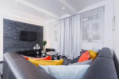 a living room with a couch with colorful pillows at Comfy Apartment Lubelska Krakow by Noclegi Renters in Kraków