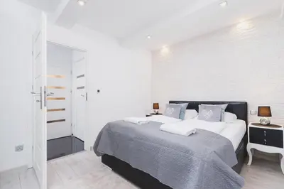 a bedroom with a bed and a white wall at Comfy Apartment Lubelska Krakow by Noclegi Renters in Kraków