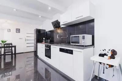 a kitchen with white cabinets and a white microwave at Comfy Apartment Lubelska Krakow by Noclegi Renters in Kraków