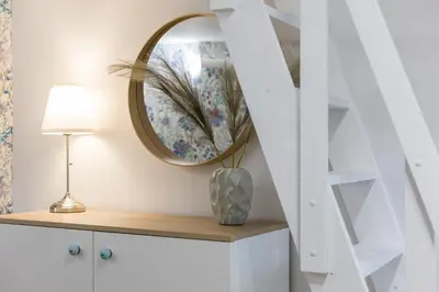 a mirror on top of a dresser with a lamp at Cracow S31 in Kraków