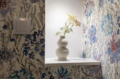 a vase sitting on a shelf in a room with wallpaper at Cracow S31 in Kraków