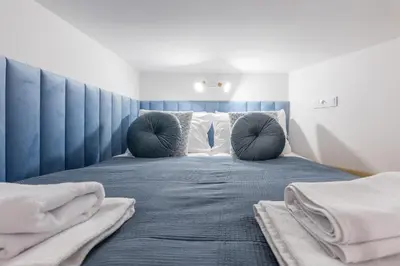 a bedroom with a blue bed with pillows at Cracow S31 in Kraków