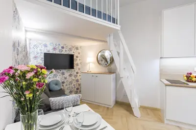 a living room with a couch and a table with flowers at Cracow S31 in Kraków