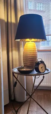 a lamp sitting on a table next to a clock at Stylish apartment in trendiest area in Kraków