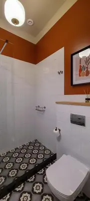 a bathroom with a toilet and a black and white tile floor at Stylish apartment in trendiest area in Kraków