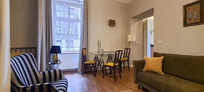 a living room with a couch and a table with chairs at Stylish apartment in trendiest area in Kraków