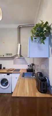 a kitchen with a sink and a washing machine at Stylish apartment in trendiest area in Kraków