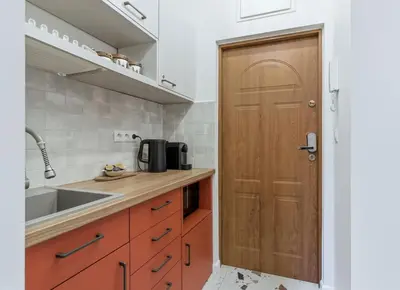 a kitchen with a wooden door and a sink at Apartament Targowy by LookAp in Kraków
