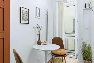 a white table and chairs in a room with a window at Apartament Targowy by LookAp in Kraków