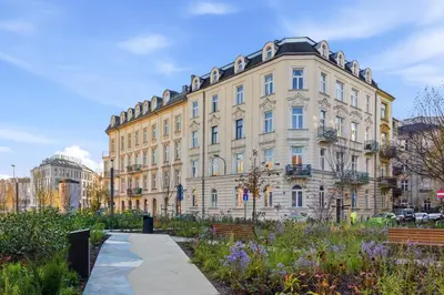 a large building with a garden in front of it at Apartament Targowy by LookAp in Kraków