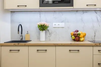 a kitchen counter with a bowl of fruit and a vase of flowers at Cracow Old Town S31 in Kraków