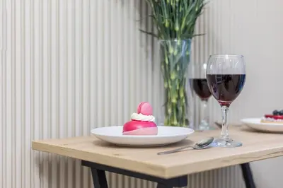 a table with a plate of food and a glass of wine at Cracow Old Town S31 in Kraków