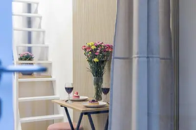 a table with a vase of flowers and two glasses of wine at Cracow Old Town S31 in Kraków