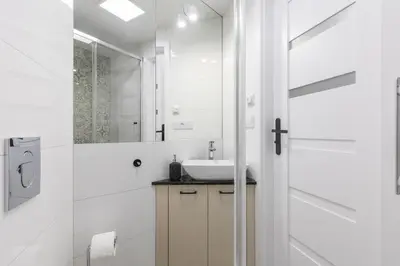 a white bathroom with a sink and a mirror at Cracow Old Town S31 in Kraków