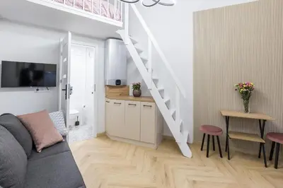 a living room with a couch and a staircase at Cracow Old Town S31 in Kraków