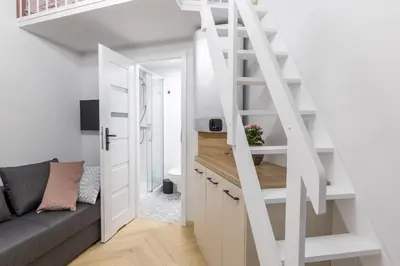 a small apartment with a staircase and a couch at Cracow Old Town S31 in Kraków