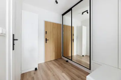 a hallway with a large mirror and white walls at Prandoty 10B by Homeprime in Kraków