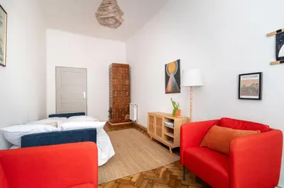 a bedroom with a bed and two red chairs at Malila Premium Apartments Cracow Sebastiana 17 Old Town in Kraków