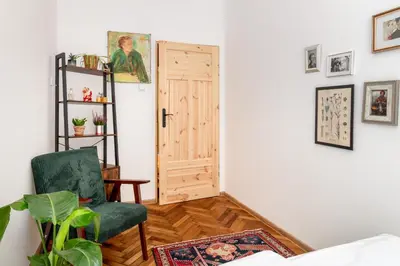 a room with a green chair and a door at Malila Premium Apartments Cracow Sebastiana 17 Old Town in Kraków