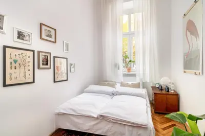 a white bedroom with a bed and pictures on the wall at Malila Premium Apartments Cracow Sebastiana 17 Old Town in Kraków