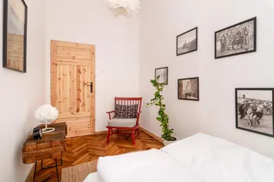 a living room with a white couch and a chair at Malila Premium Apartments Cracow Sebastiana 17 Old Town in Kraków
