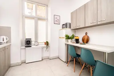 a kitchen with a counter and some blue chairs at Malila Premium Apartments Cracow Sebastiana 17 Old Town in Kraków