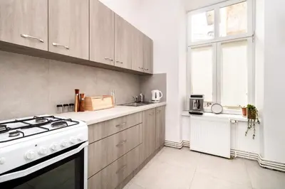 a kitchen with a white stove top oven next to a window at Malila Premium Apartments Cracow Sebastiana 17 Old Town in Kraków