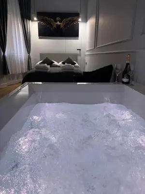 a bath tub filled with water in a room at Apartament Grey Prywatne Jacuzzi Miodowa Kraków in Kraków