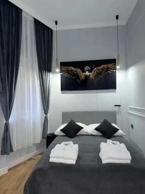 a bedroom with a bed with two towels on it at Apartament Grey Prywatne Jacuzzi Miodowa Kraków in Kraków