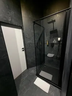 a bathroom with a shower with a glass door at Apartament Grey Prywatne Jacuzzi Miodowa Kraków in Kraków