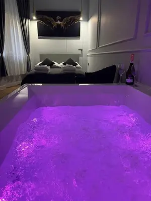 a purple bath tub filled with pink algae in a room at Apartament Grey Prywatne Jacuzzi Miodowa Kraków in Kraków
