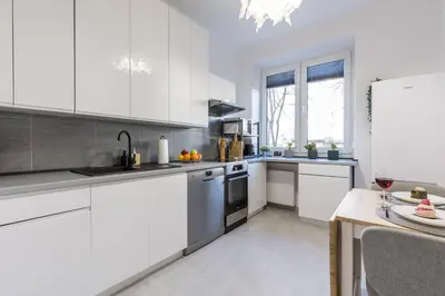 a kitchen with white cabinets and a white refrigerator at 3 Rooms Comfort Capybara Apartment Free Parking by CityBeat in Kraków