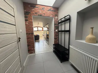 a hallway with a brick wall and a door at Grodzka Loft in Kraków