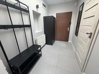 a hallway with a black bench and a door at Grodzka Loft in Kraków