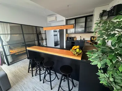 a kitchen with a counter with stools at a bar at Grodzka Loft in Kraków