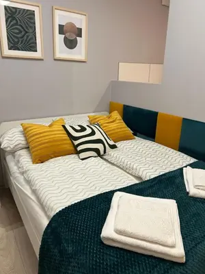 a bed with two pillows on it in a room at Solna Studio Apartment - Comfort Stay in Heart of Kraków in Kraków